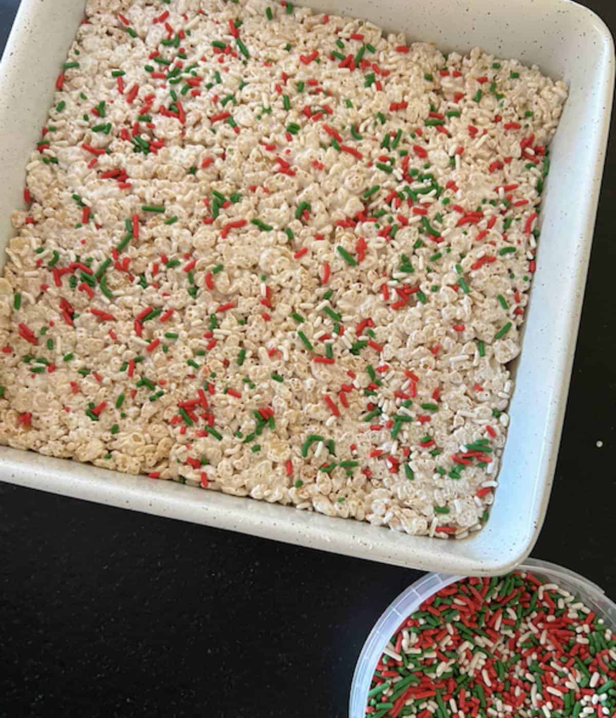 Rice krispie squares in pan with sprinkles.