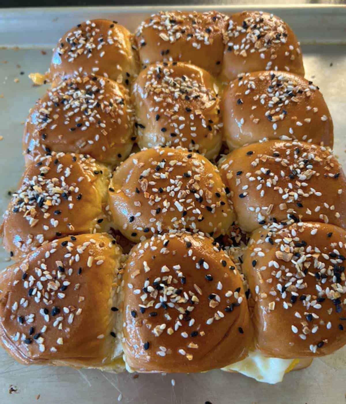 Hawaiian sliders topped with butter and everything bagel seasoning.