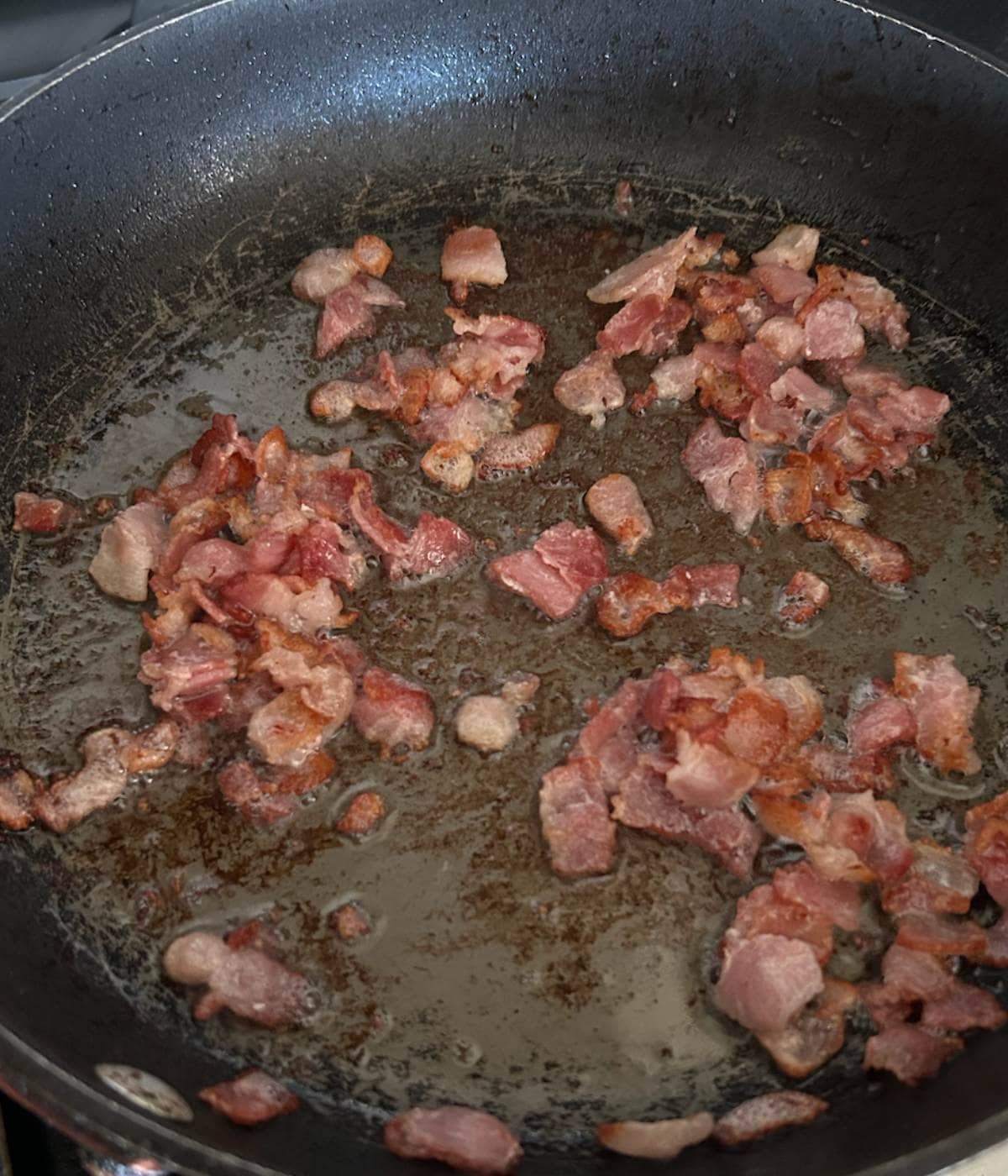 Crispy bacon frying in pan.