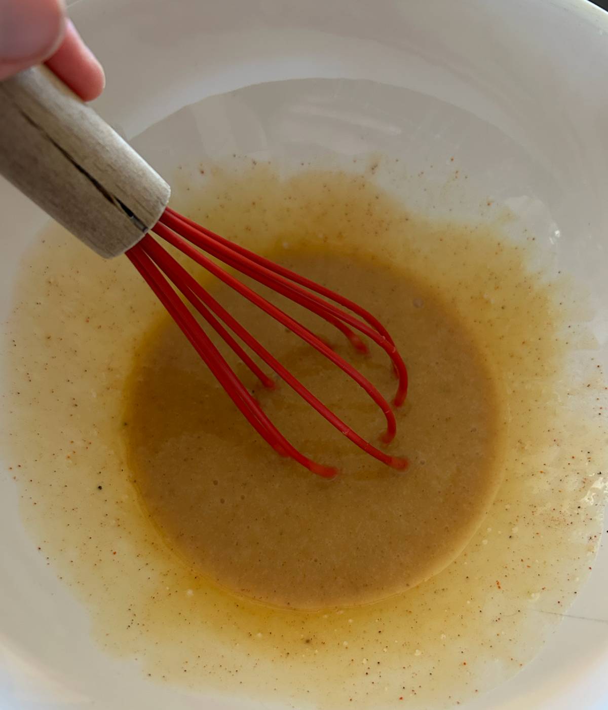 Whisking honey mustard in bowl.