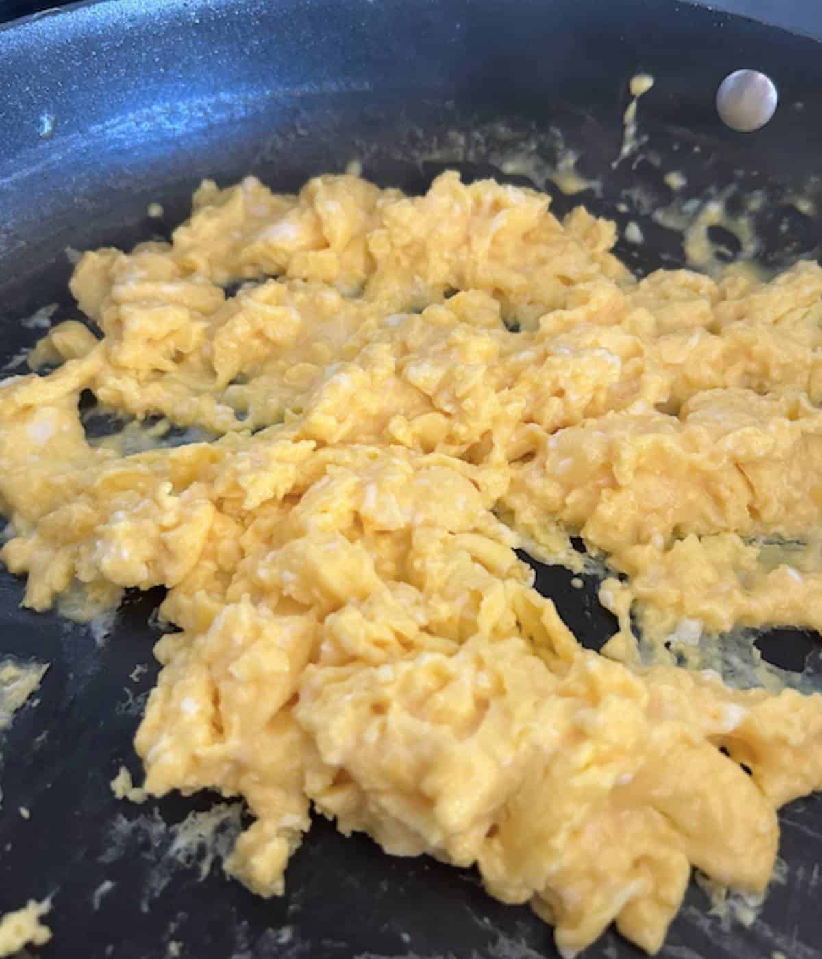 Scrambled eggs in skillet.