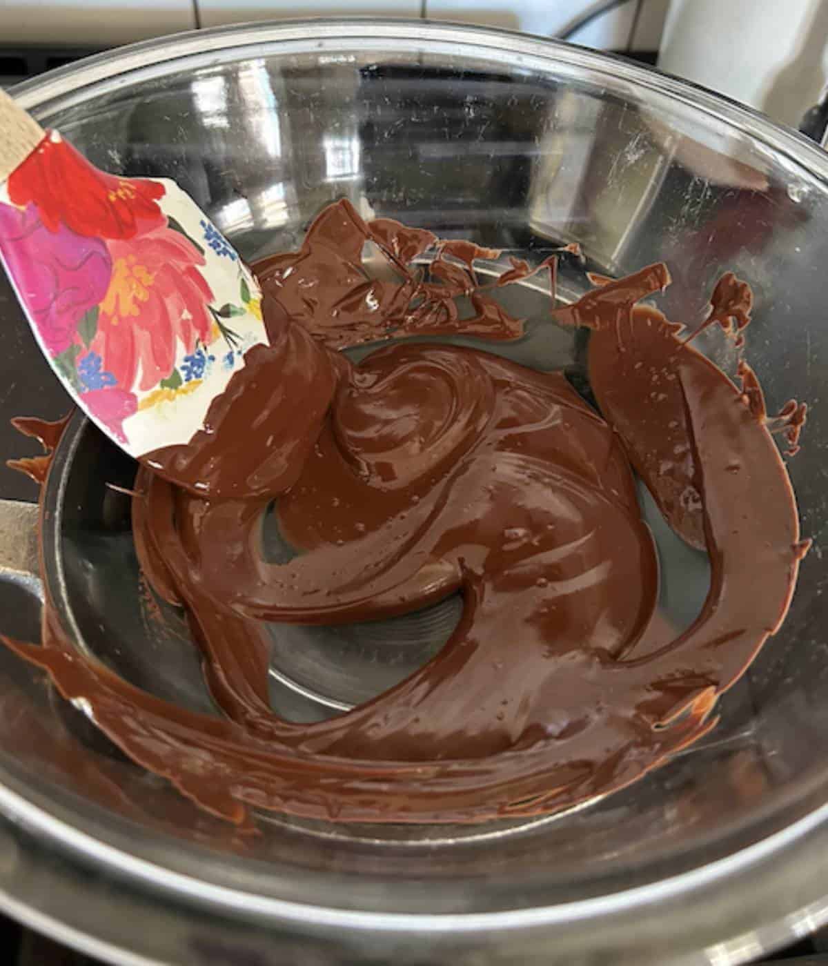 Melted dark chocolate in glass bowl.