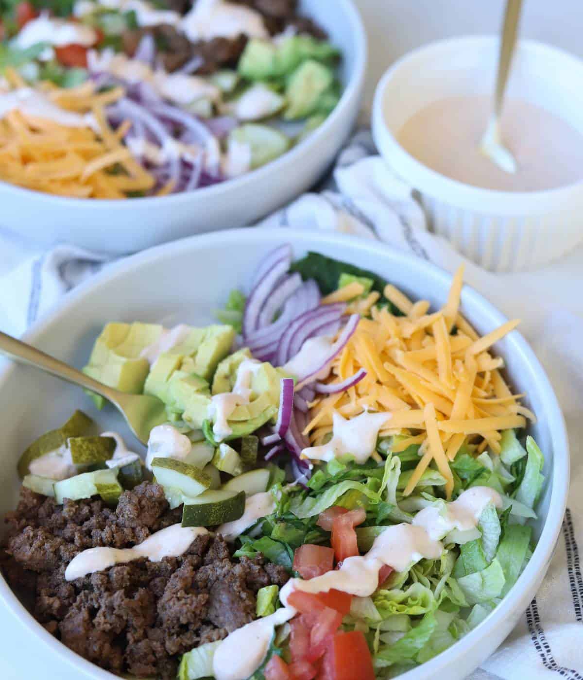Cheeseburger bowls topped with chipotle ranch dressing. 