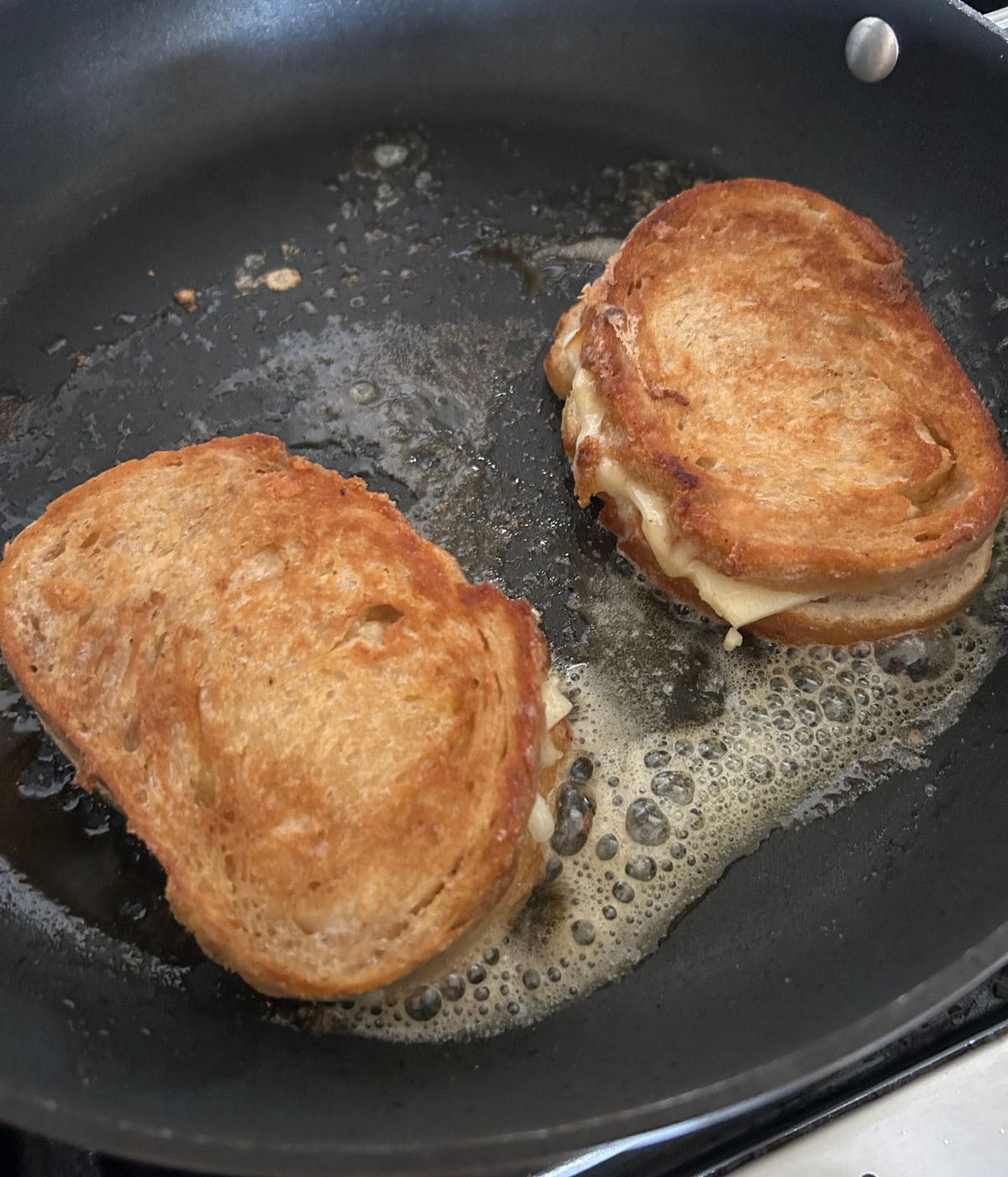 Golden toasted grilled cheese in pan.