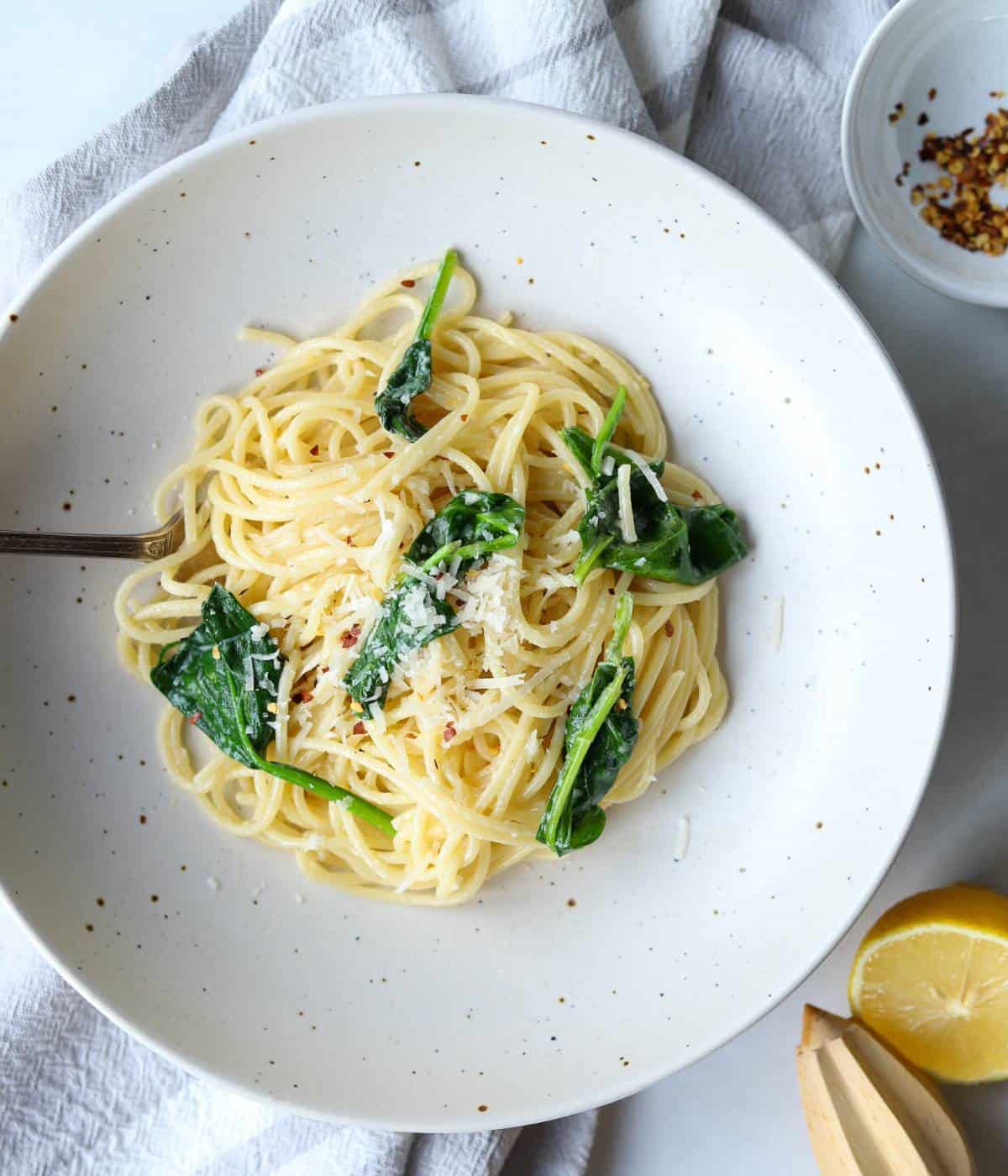 Lemon pasta with spinach in bowl with fork.