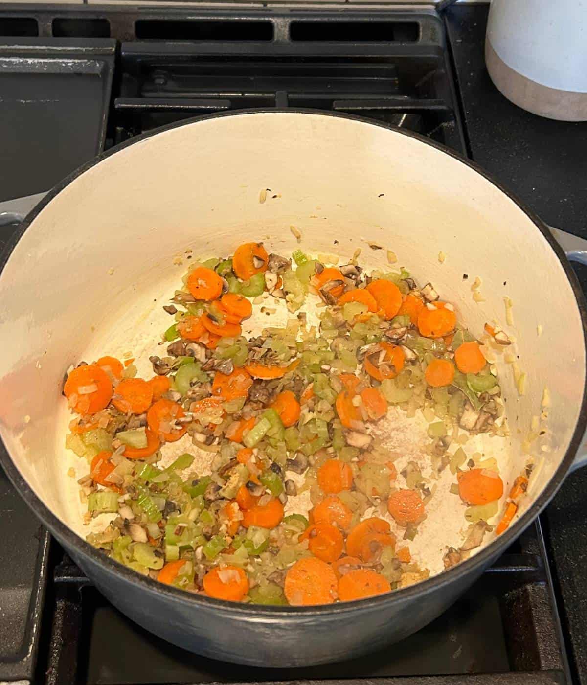 Mirepoix with mushrooms in pot.