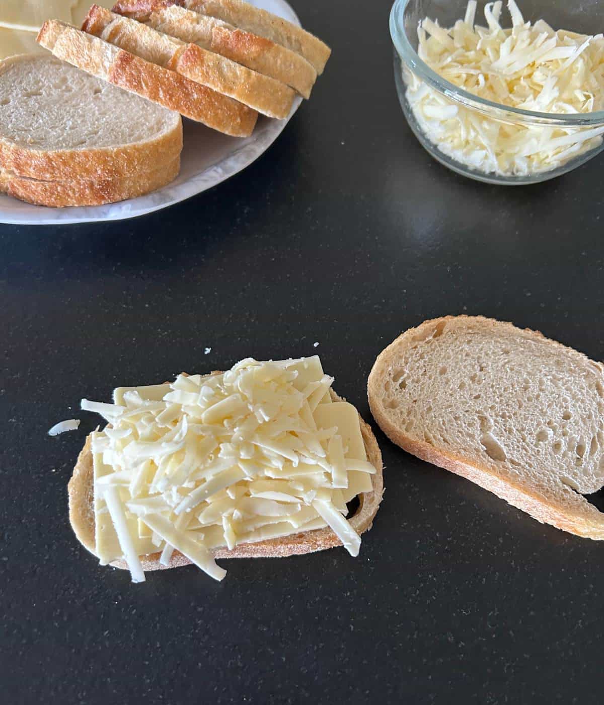 Layering cheese on sourdough bread slice.