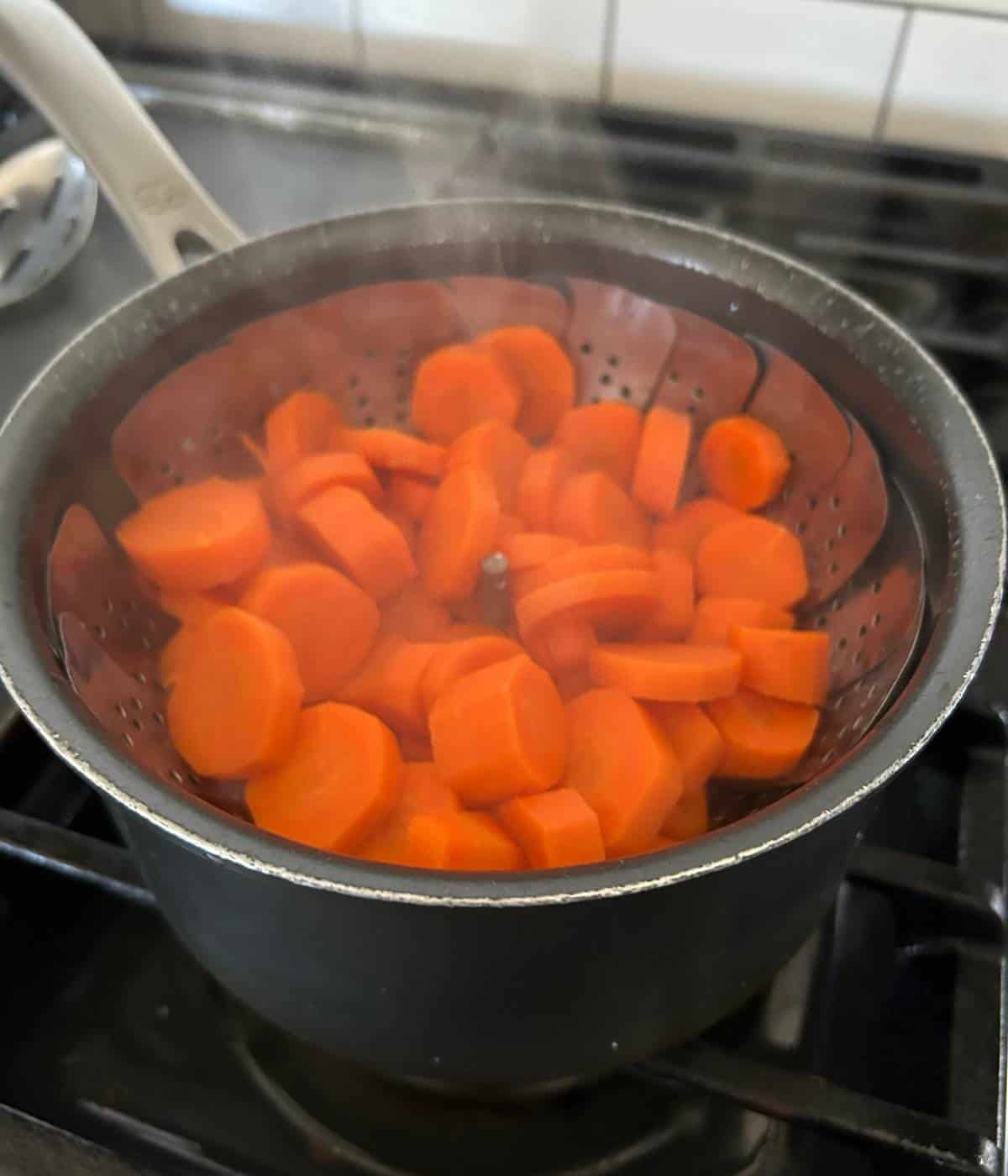 Carrots steaming in pot.