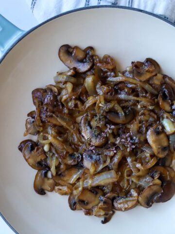 Caramelized onions and mushrooms in skillet.