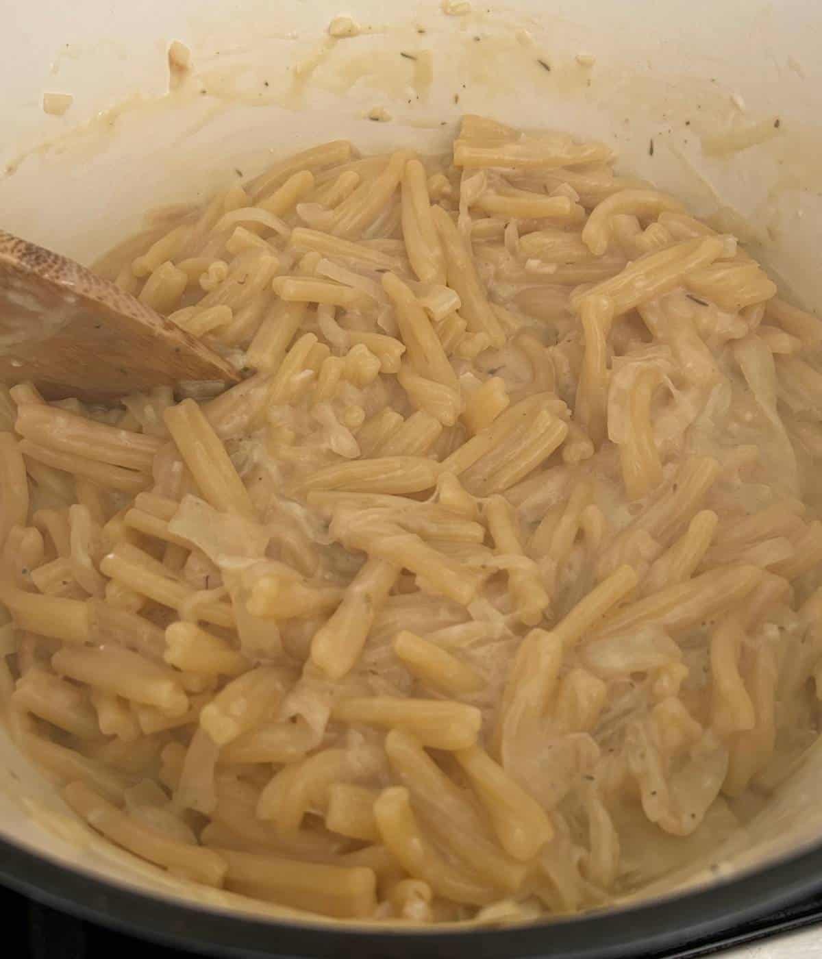 Creamy French onion soup pasta in pot.
