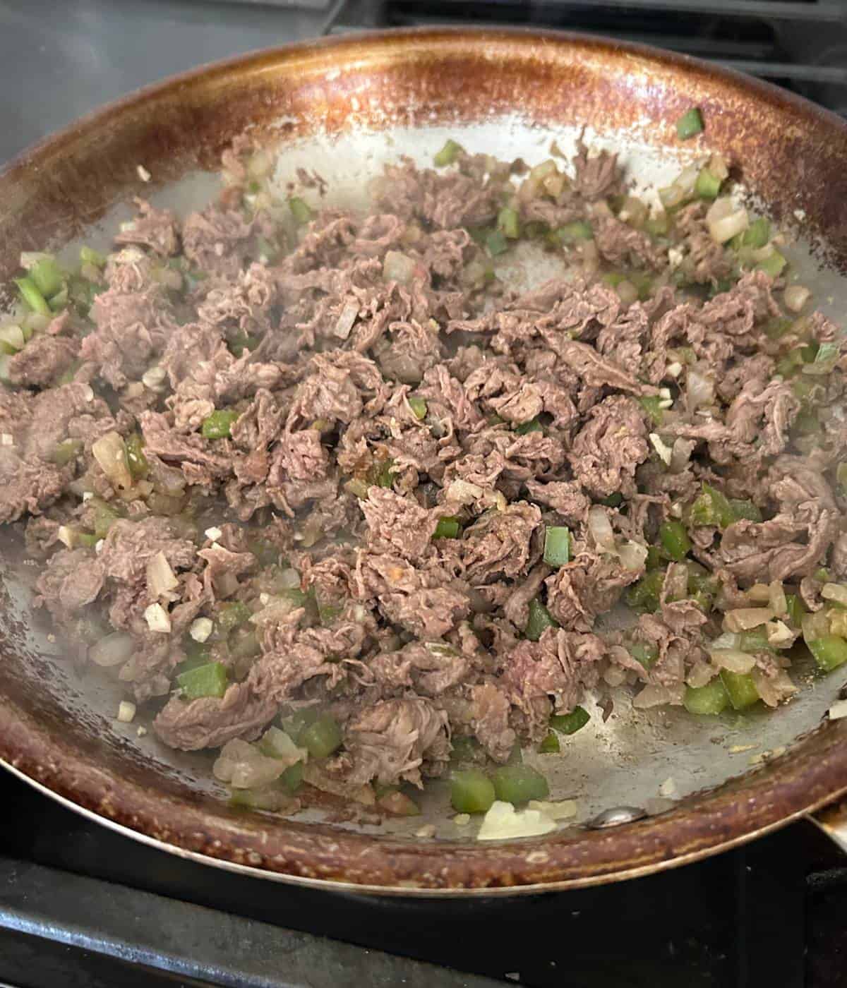 Philly cheesesteak filling in skillet.