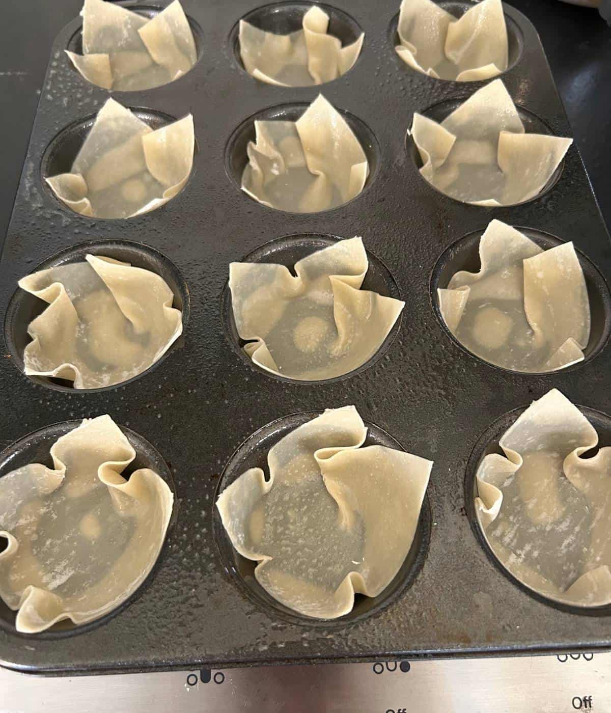 Wonton wraps in muffin tin sprayed with cooking spray.