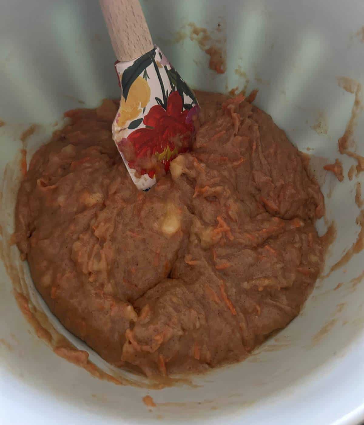 Batter for banana carrot muffins in blue bowl.