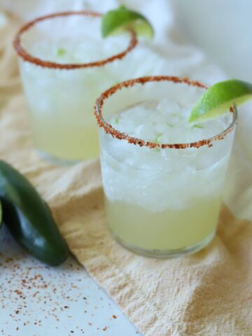 Lime margaritas with Tajín rim and lime wedges.