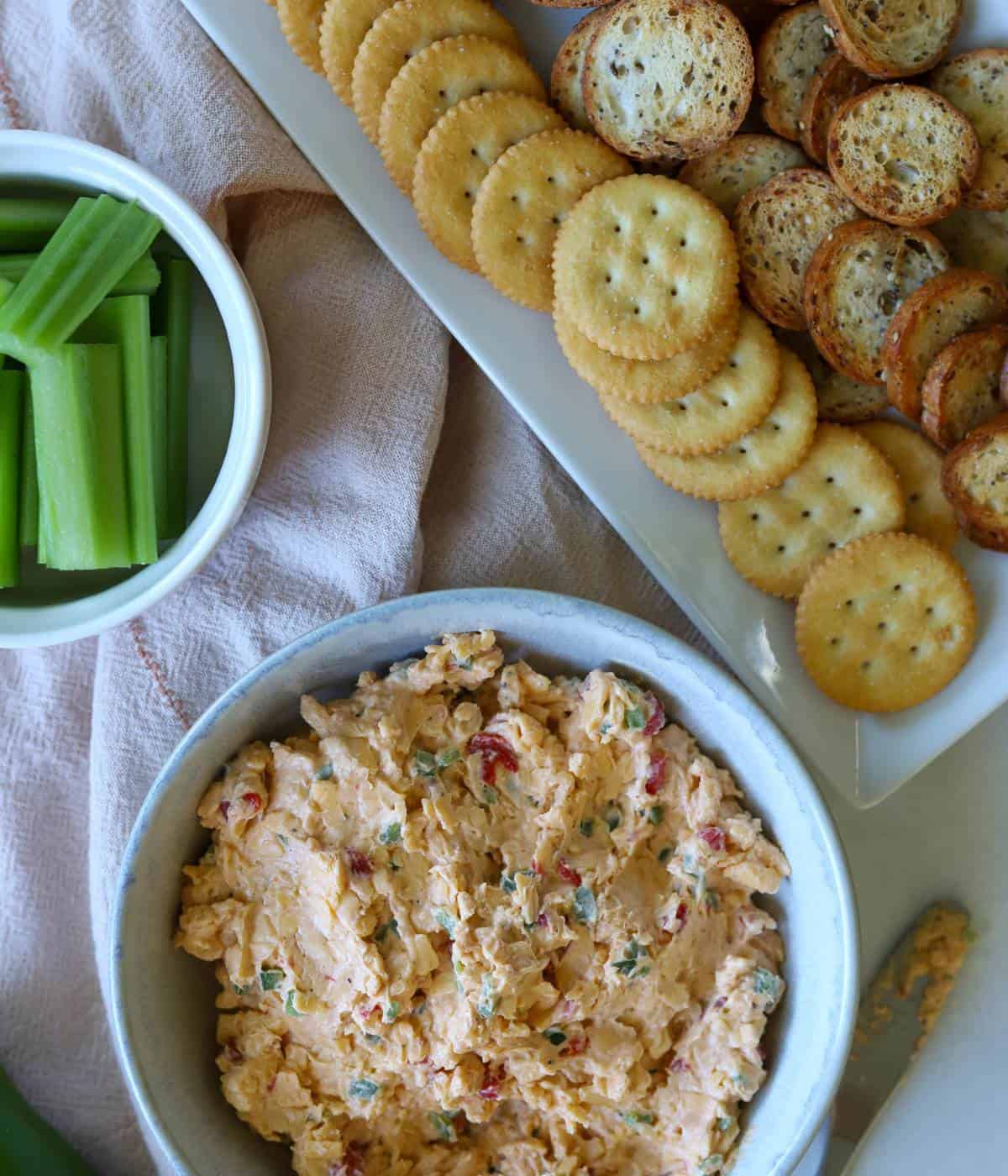 Pimento cheese spread with crackers and celery on side.