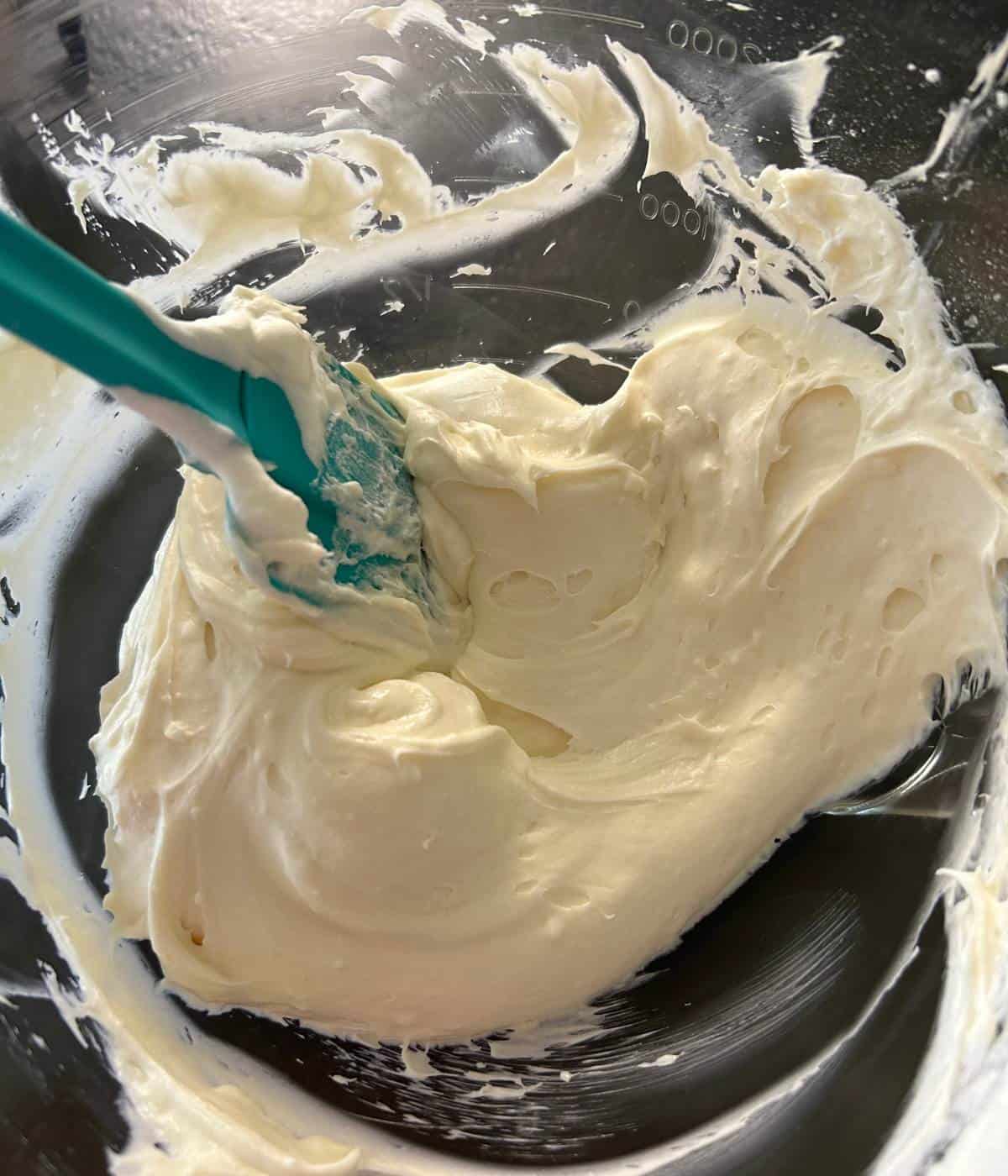Cream cheese with whipping cream in bowl.