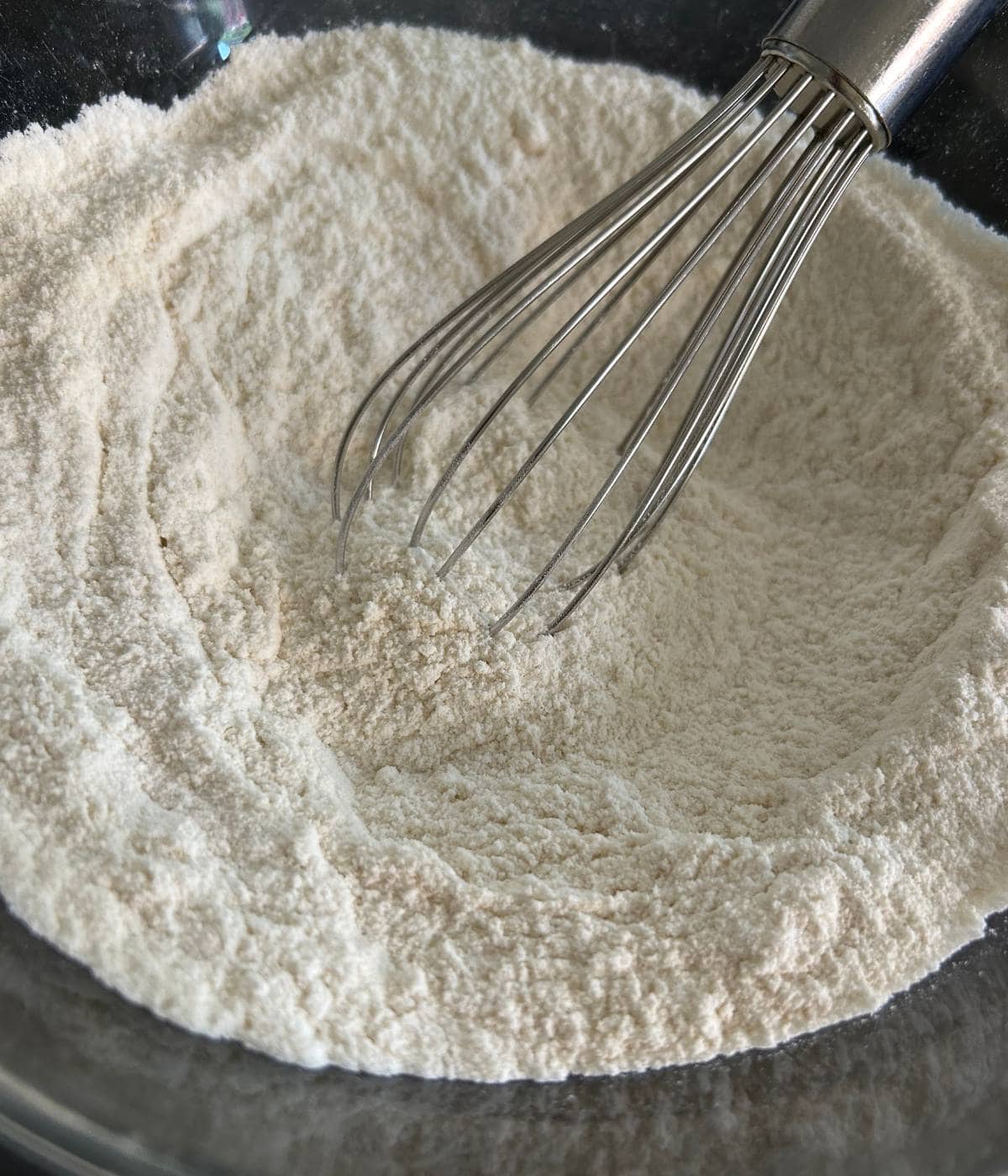 Dry ingredients in bowl with whisk.