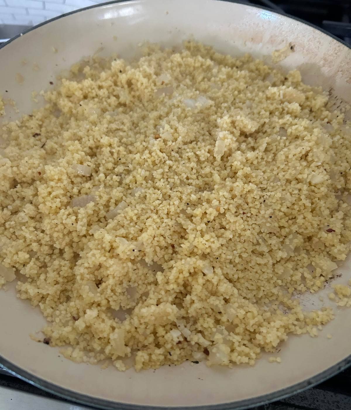 Fluffy couscous in pan.