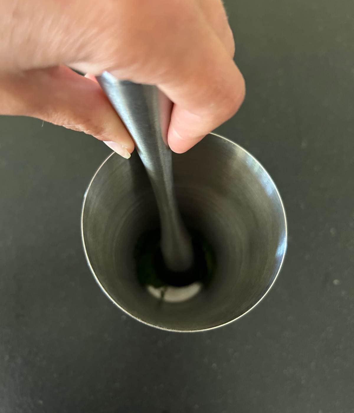 Muddling mint in shaker cup.