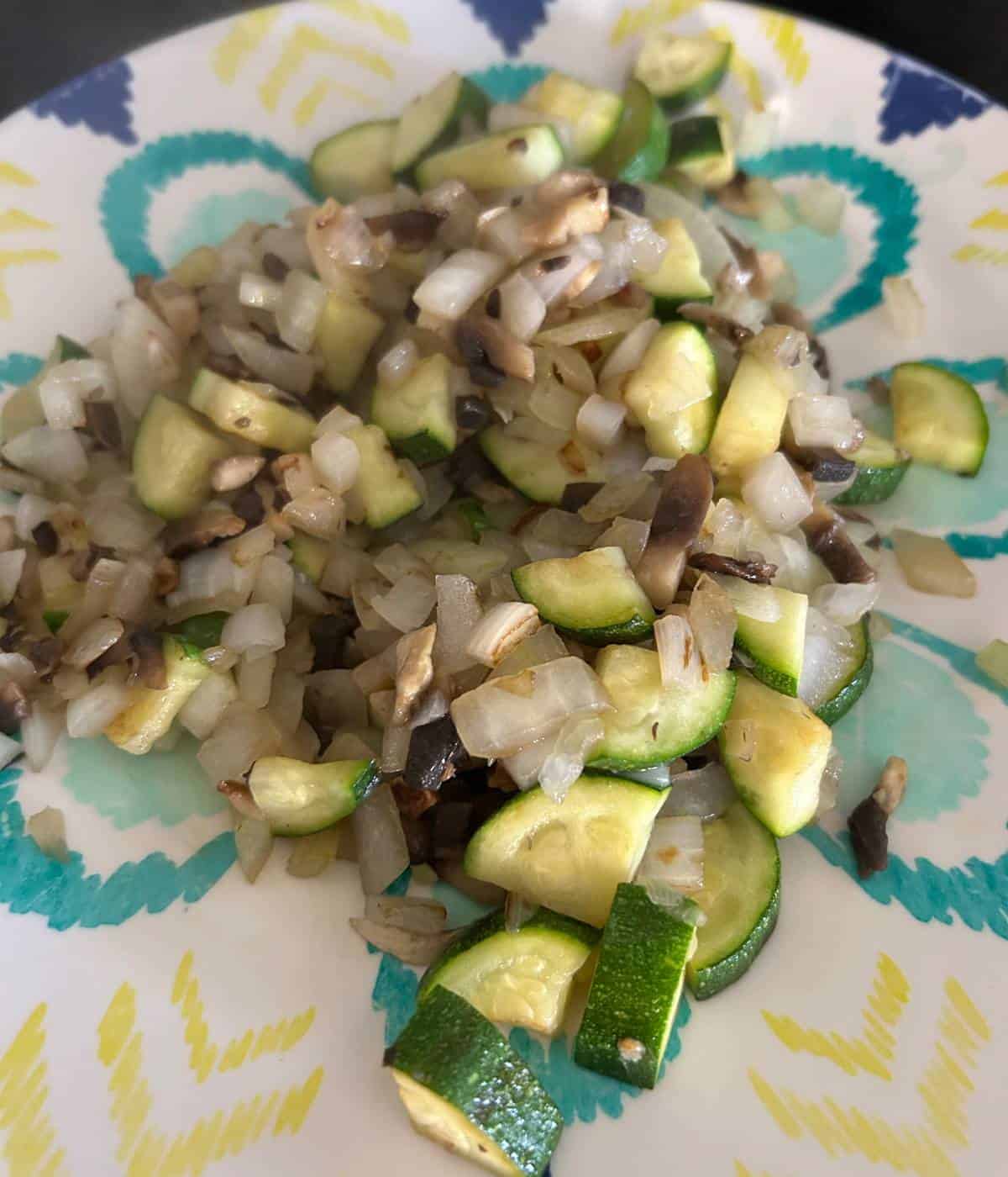 Mushroom, onion, zucchini on plate.