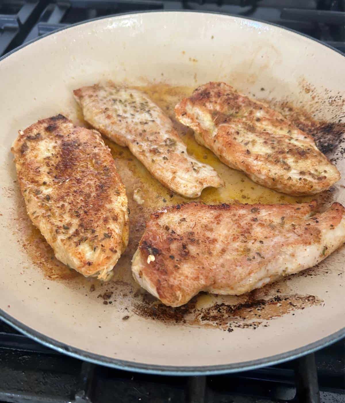 Chicken sautéing in skillet.