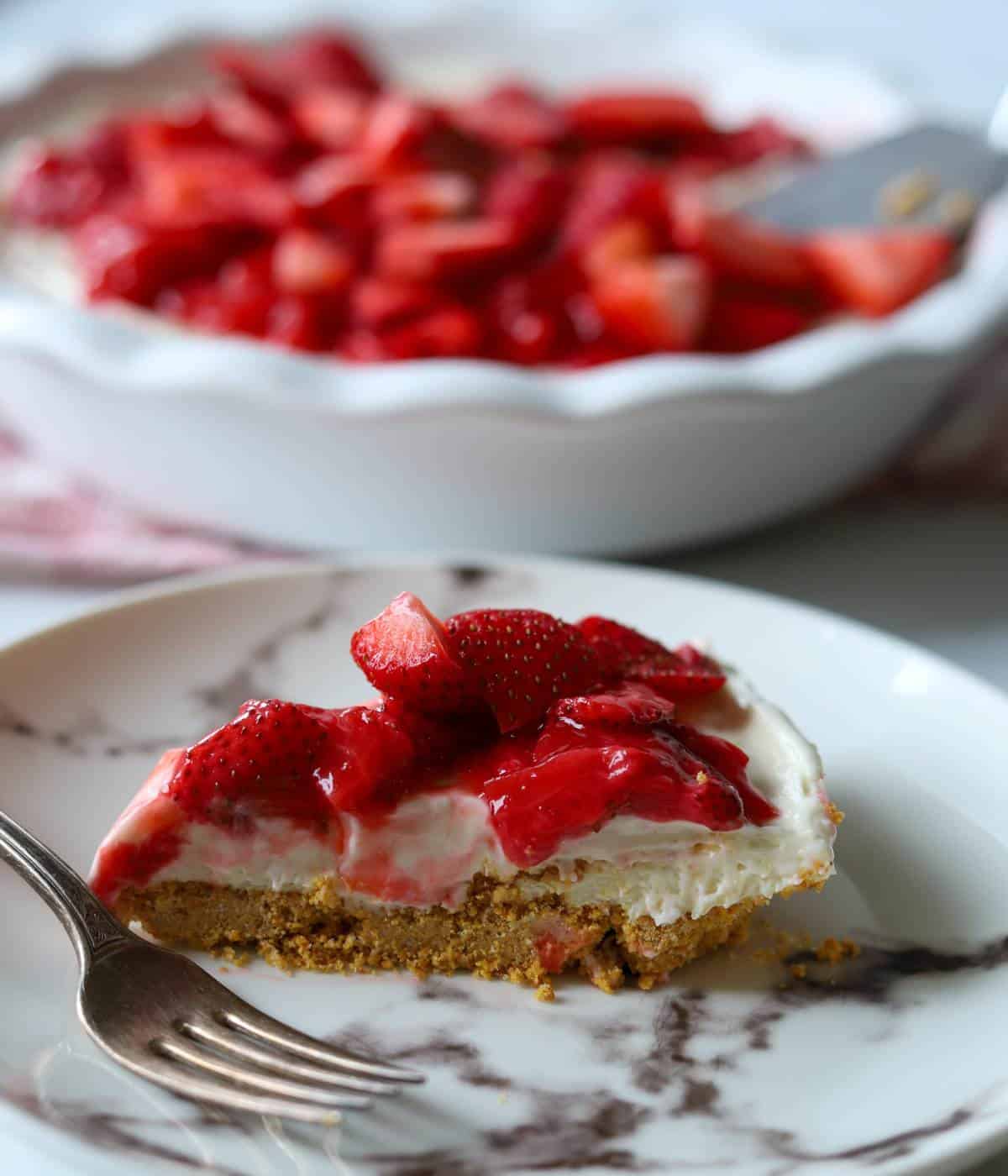 Slice of strawberry pie on plate with fork.