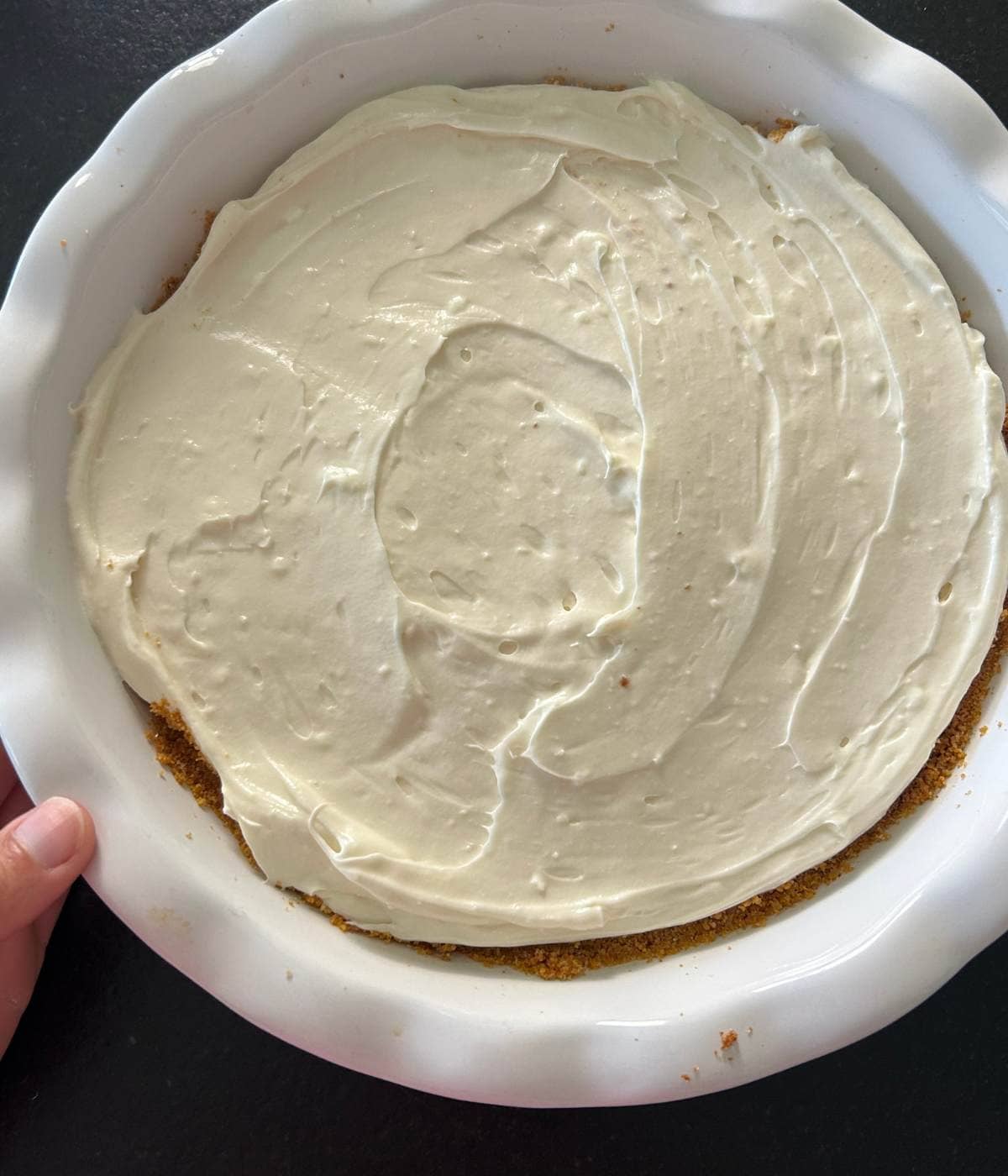 Cream cheese layer over graham cracker crust in pie plate.