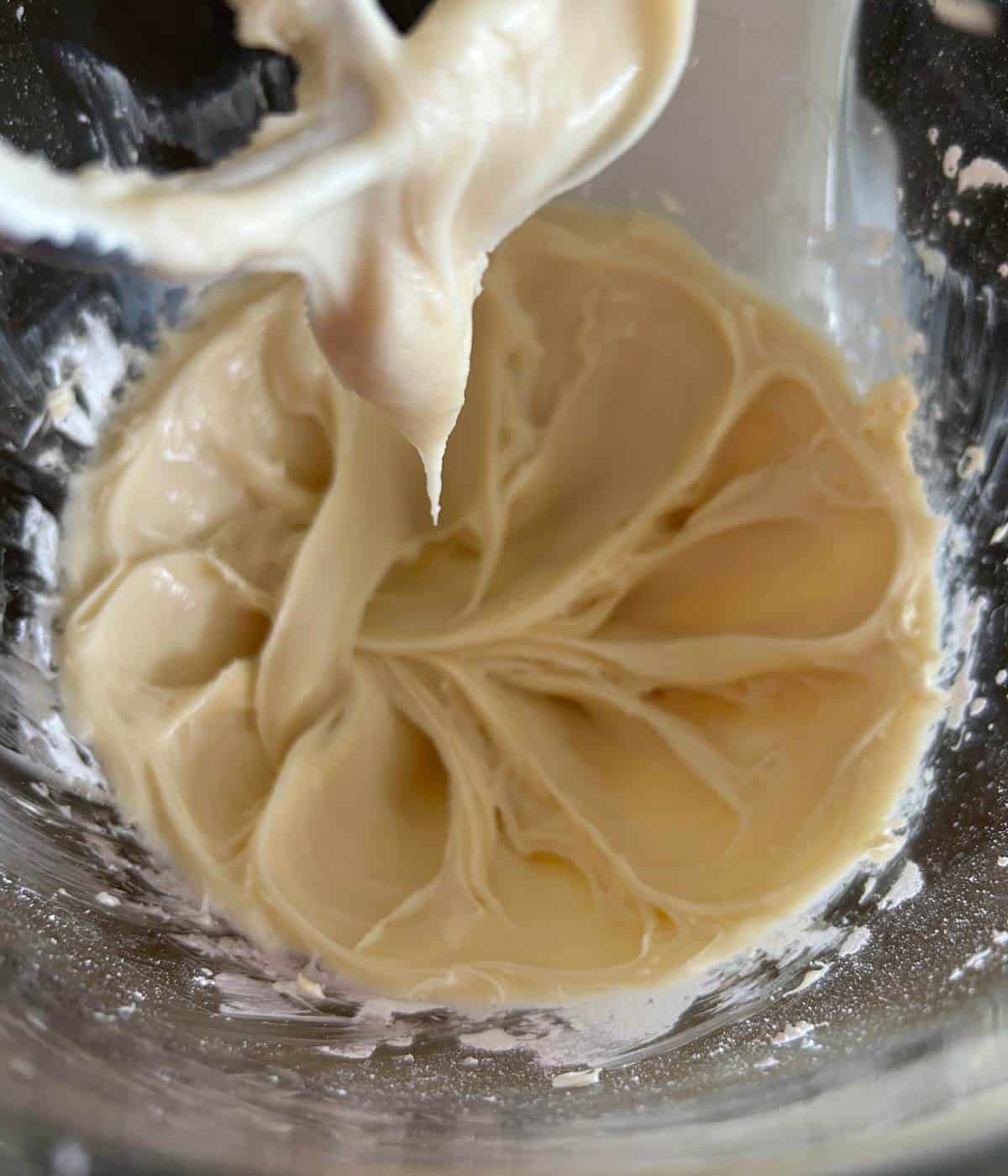 Cream cheese in mixer with powdered sugar.