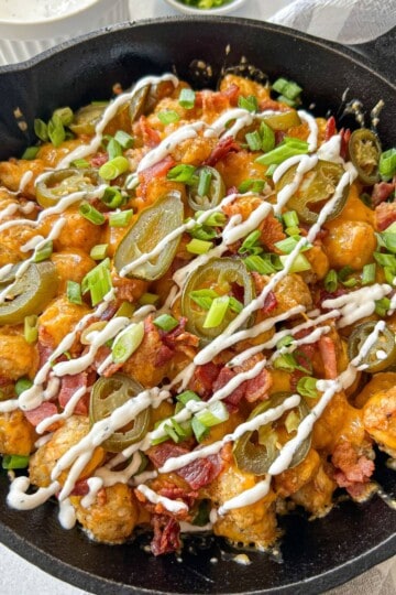 Tater tots with cheese bacon and ranch sauce.