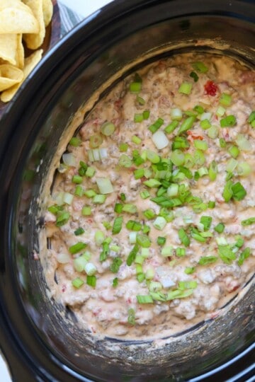Sausage rotel dip in slow cooker with chips.