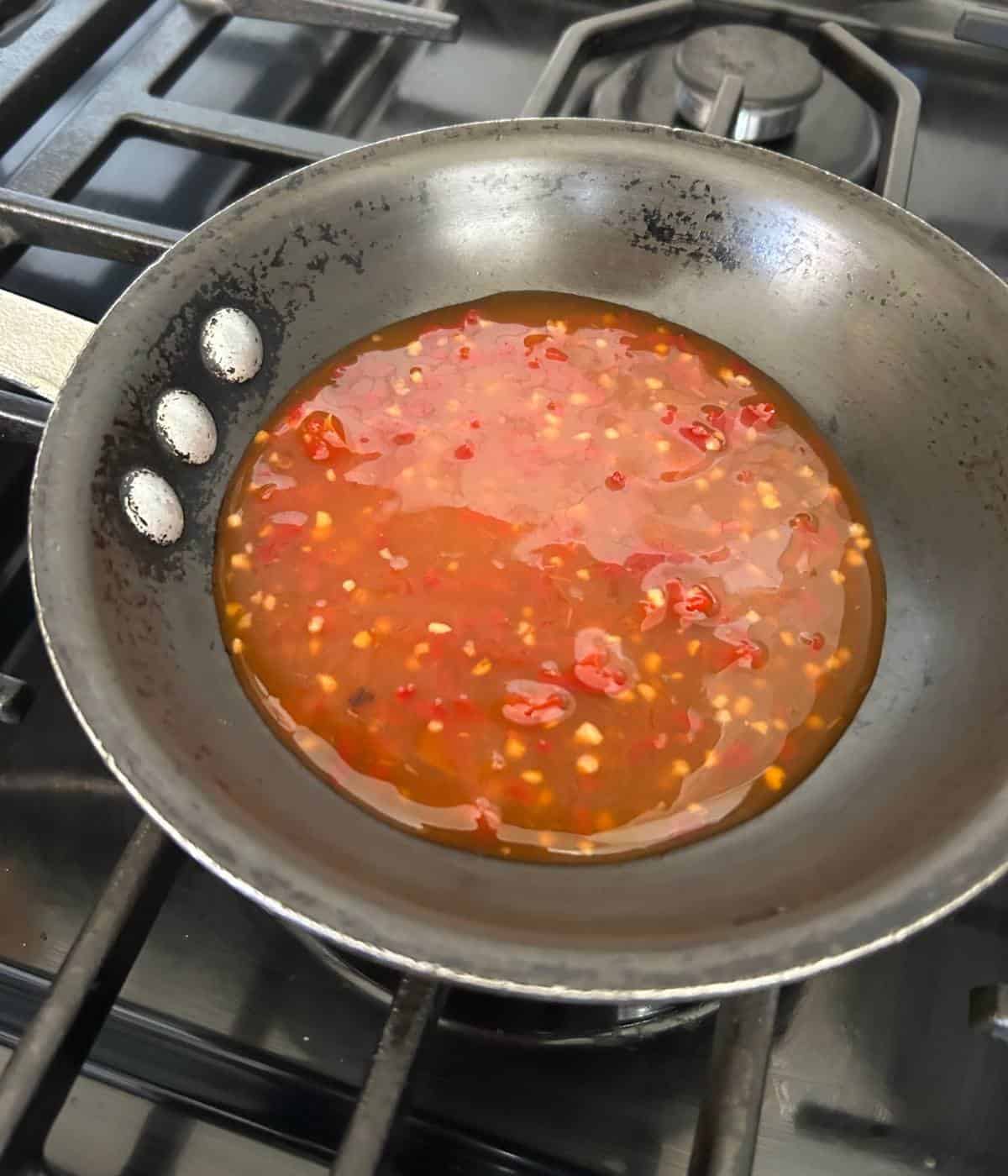 Heating up Thai chili sauce in pan.