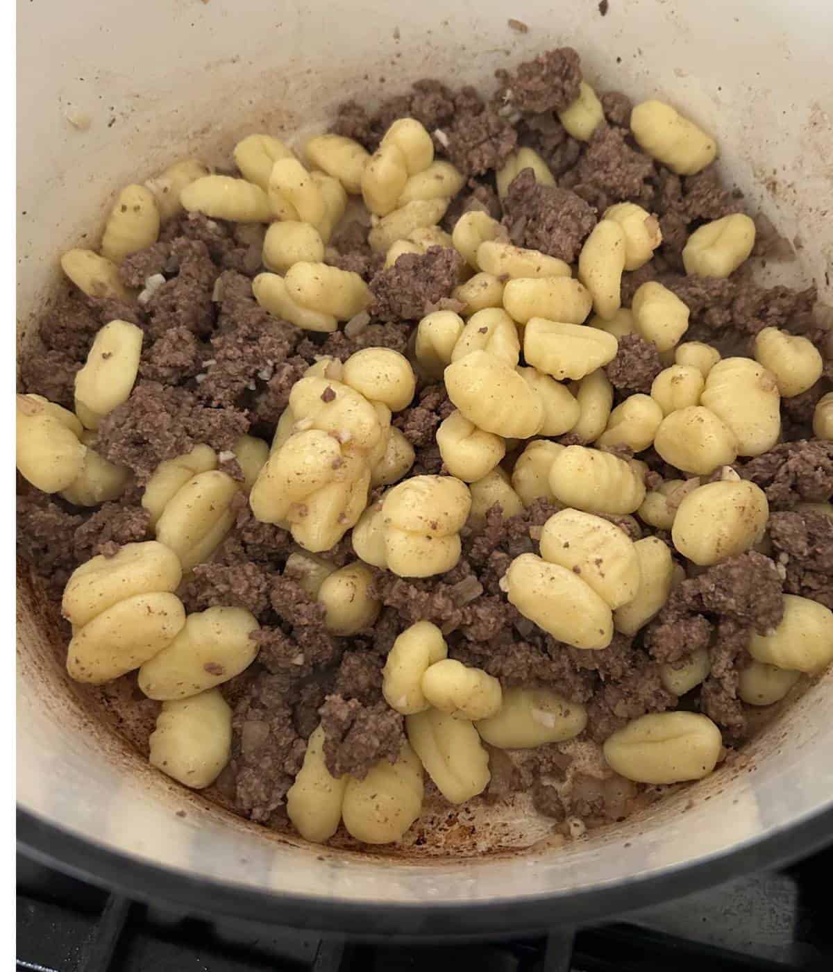 Ground Beef and gnocchi in pot.