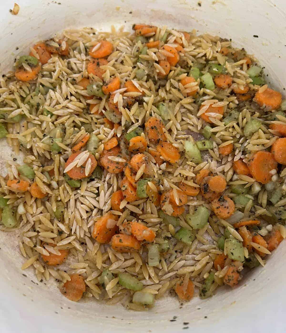 Toasting orzo with veggies.