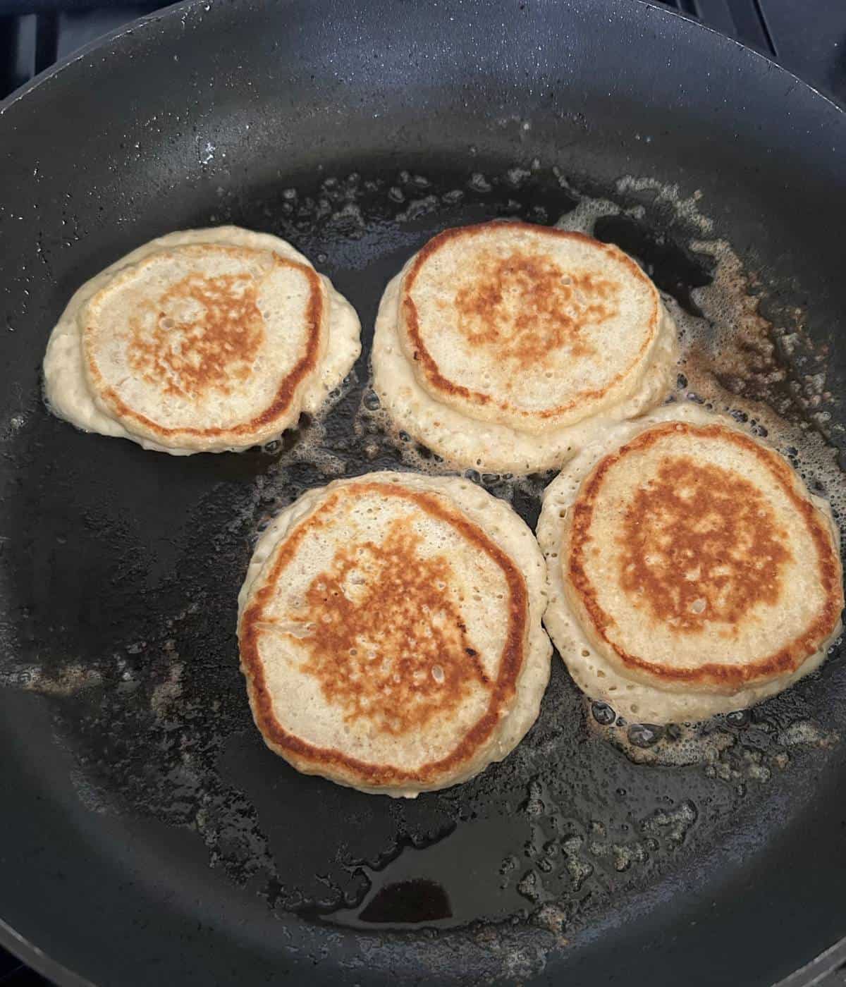Pancakes cooking in skillet.