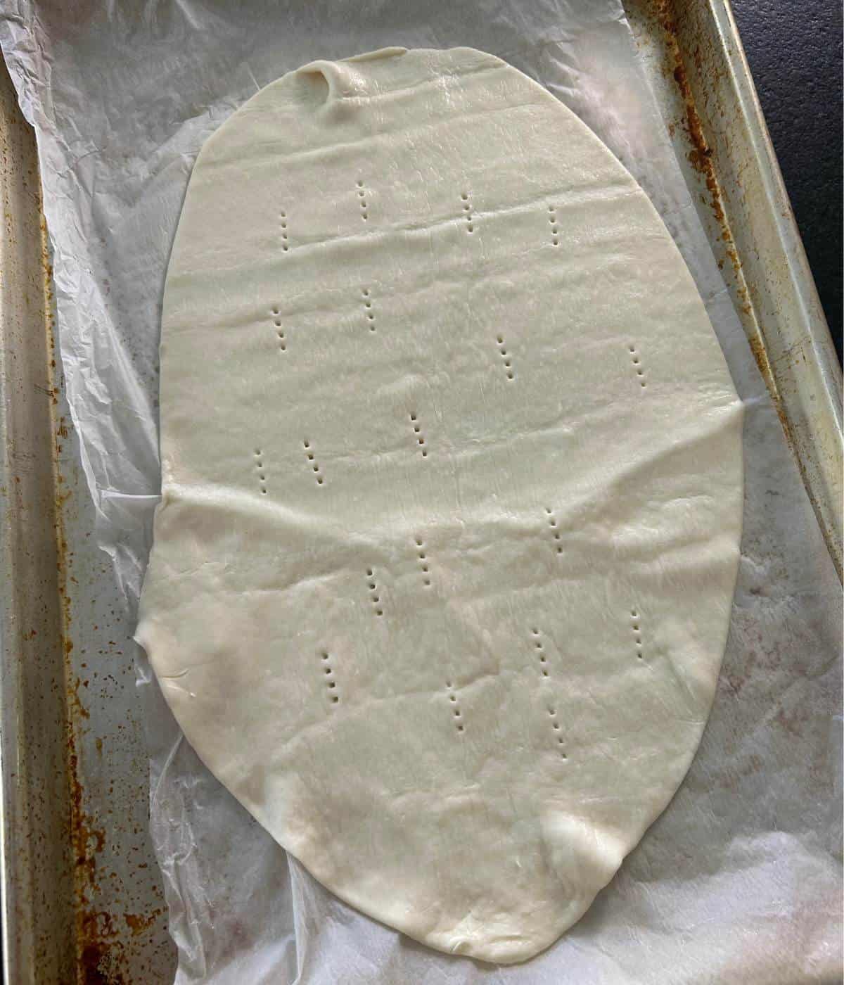 Oval shape cut puff pastry with fork pricks.