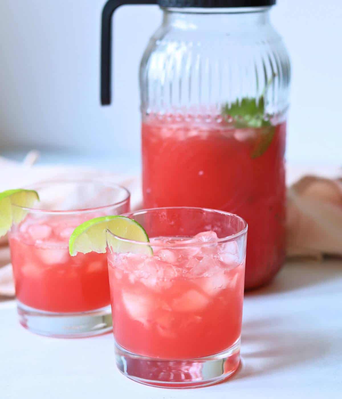 Watermelon water in a pitcher with two glasses.