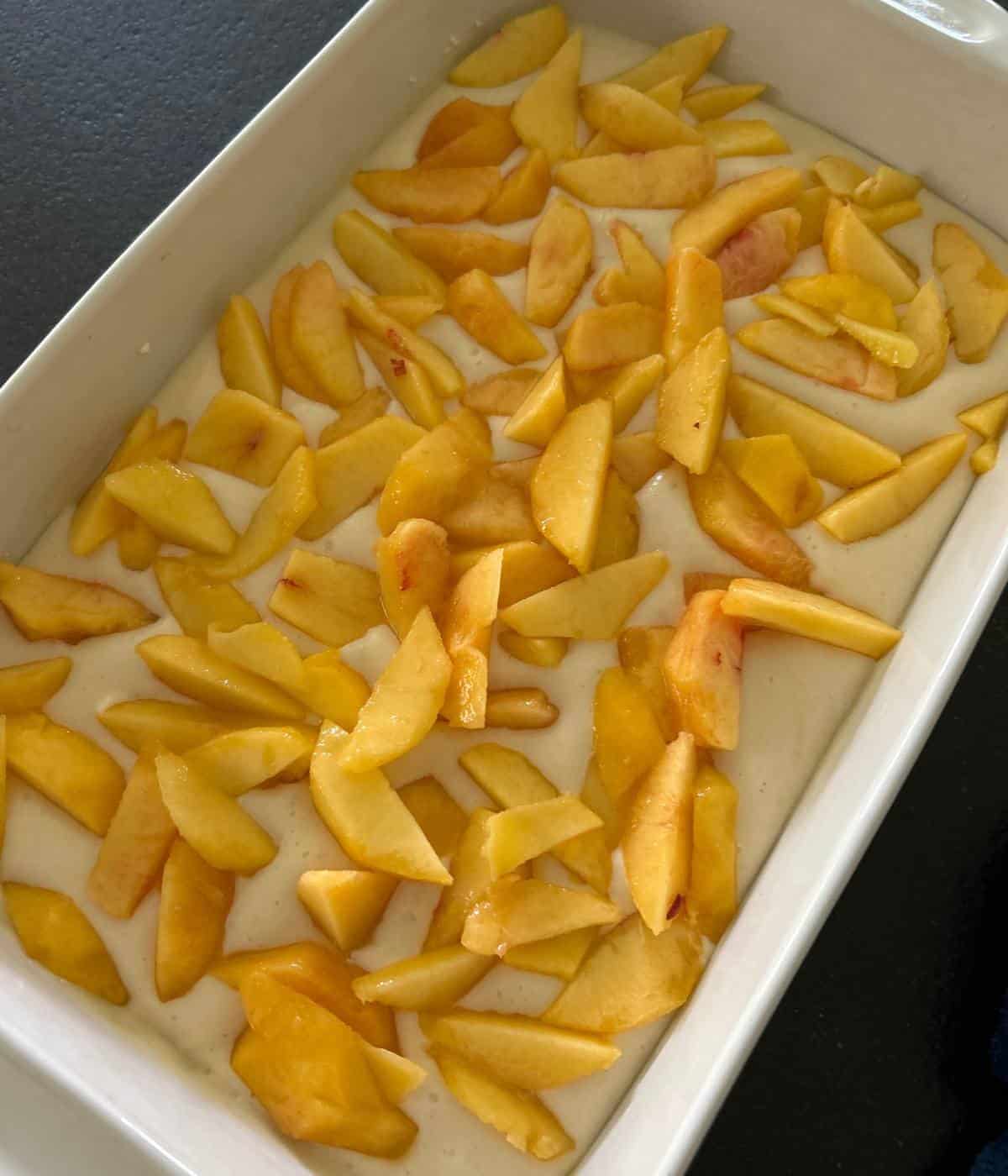 White cake topped with fresh peaches.