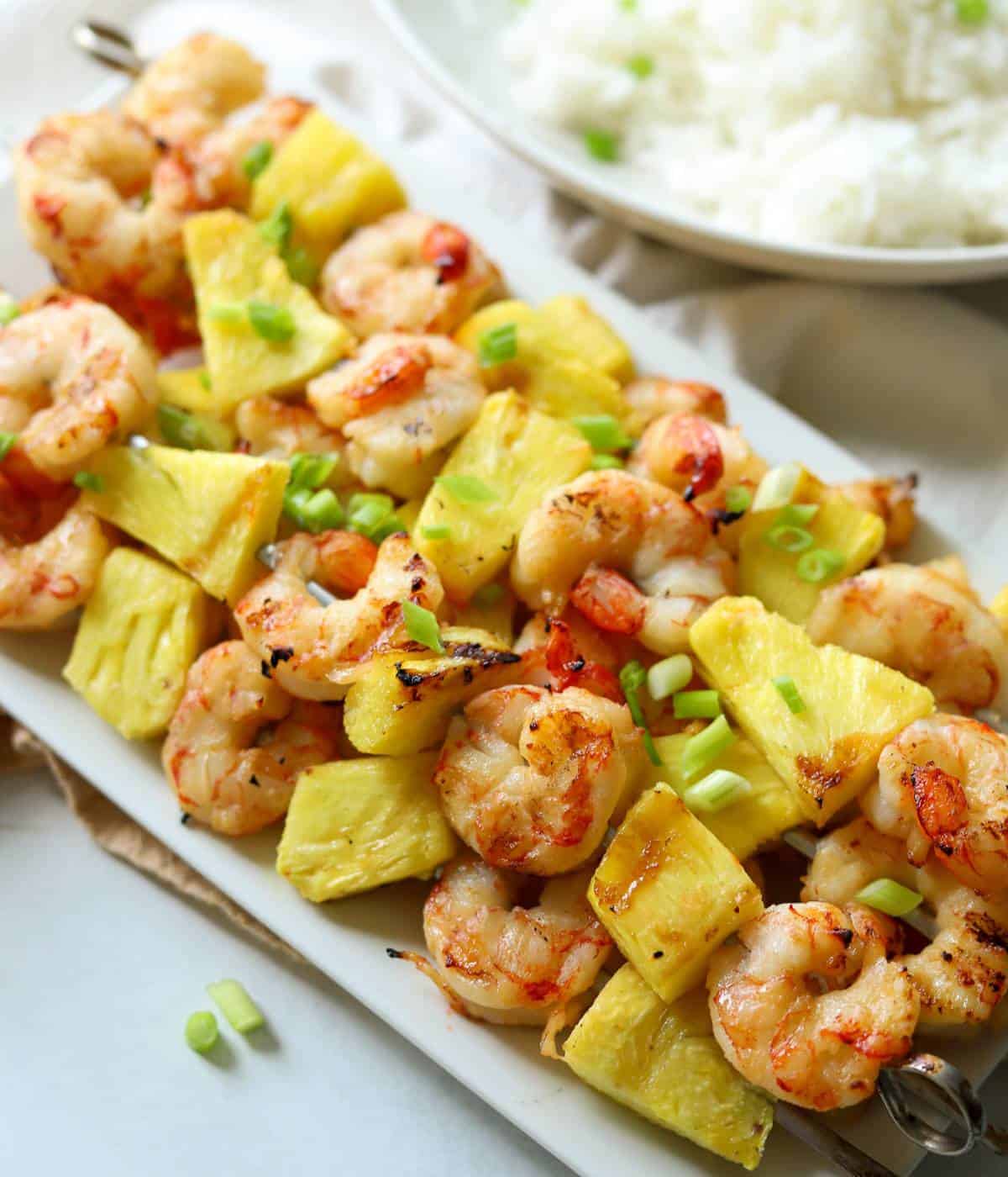 Shrimp kabobs with pineapple on serving dish.