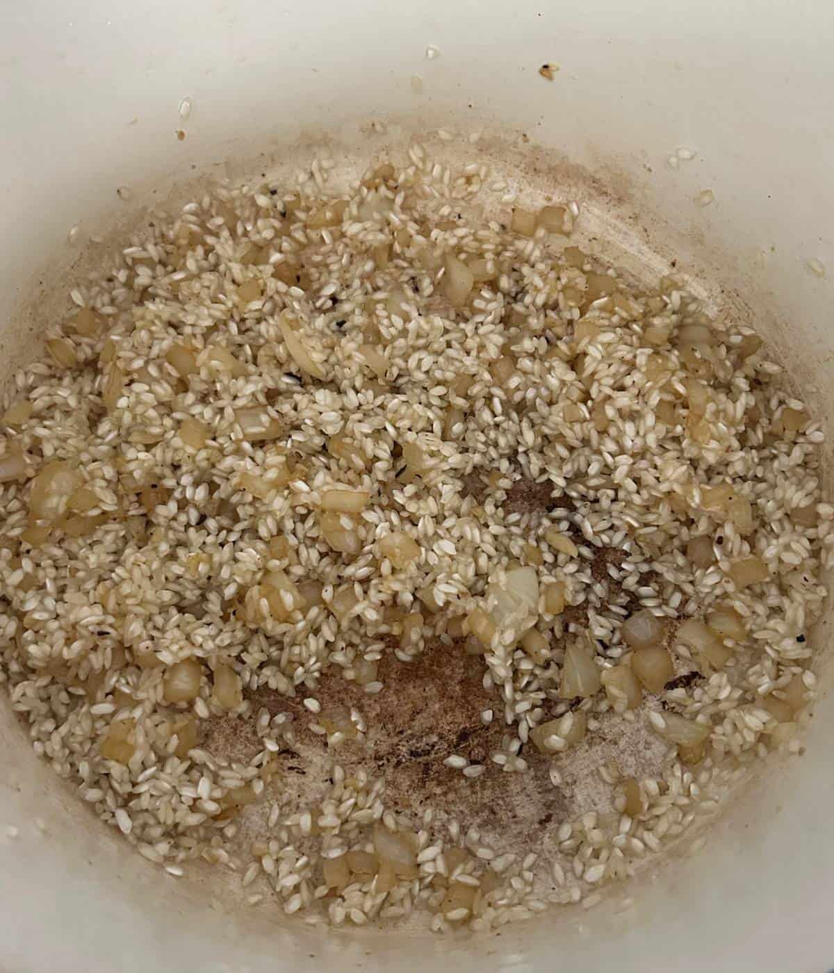 Toasting arborio rice and garlic for risotto.