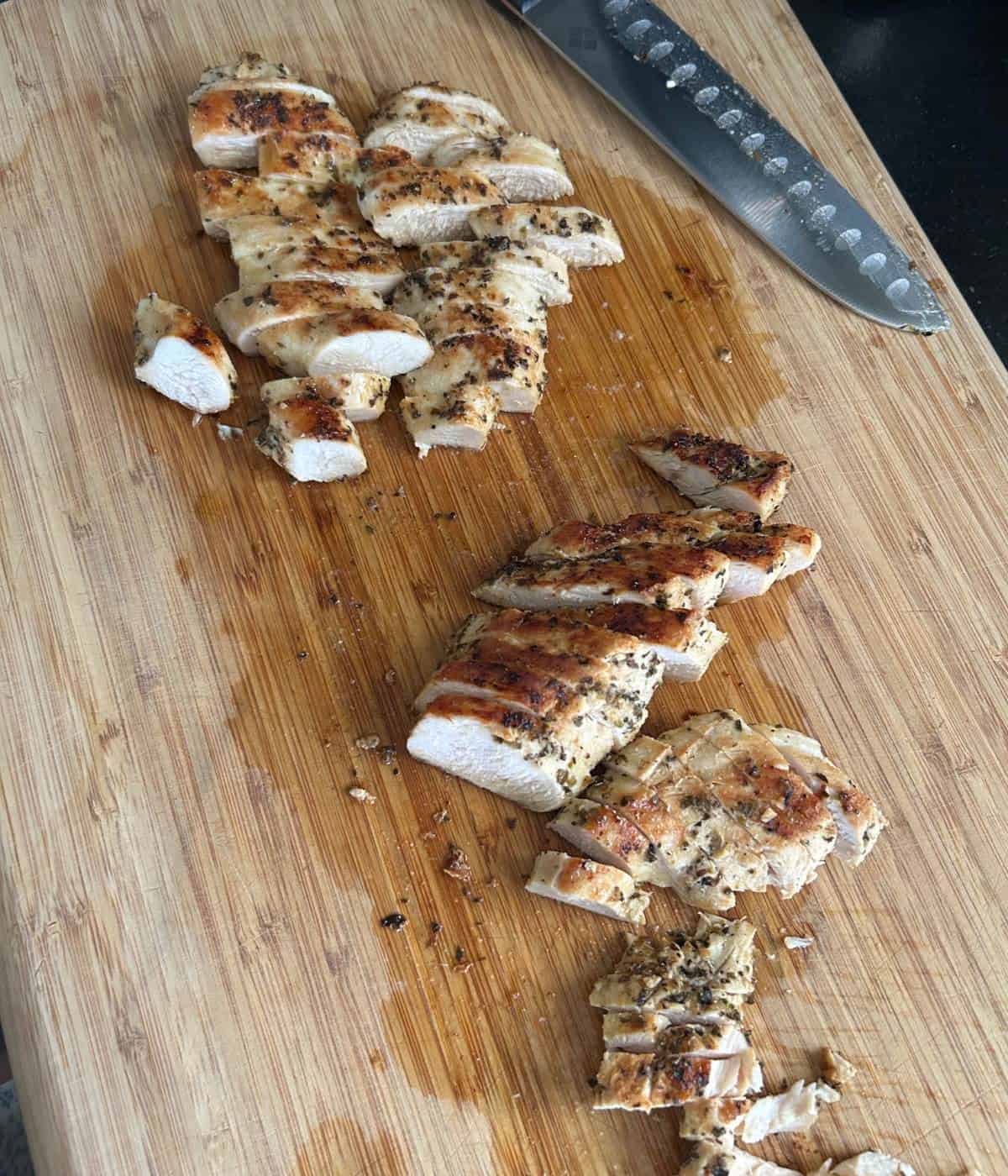 Sliced chicken breast on cutting board.