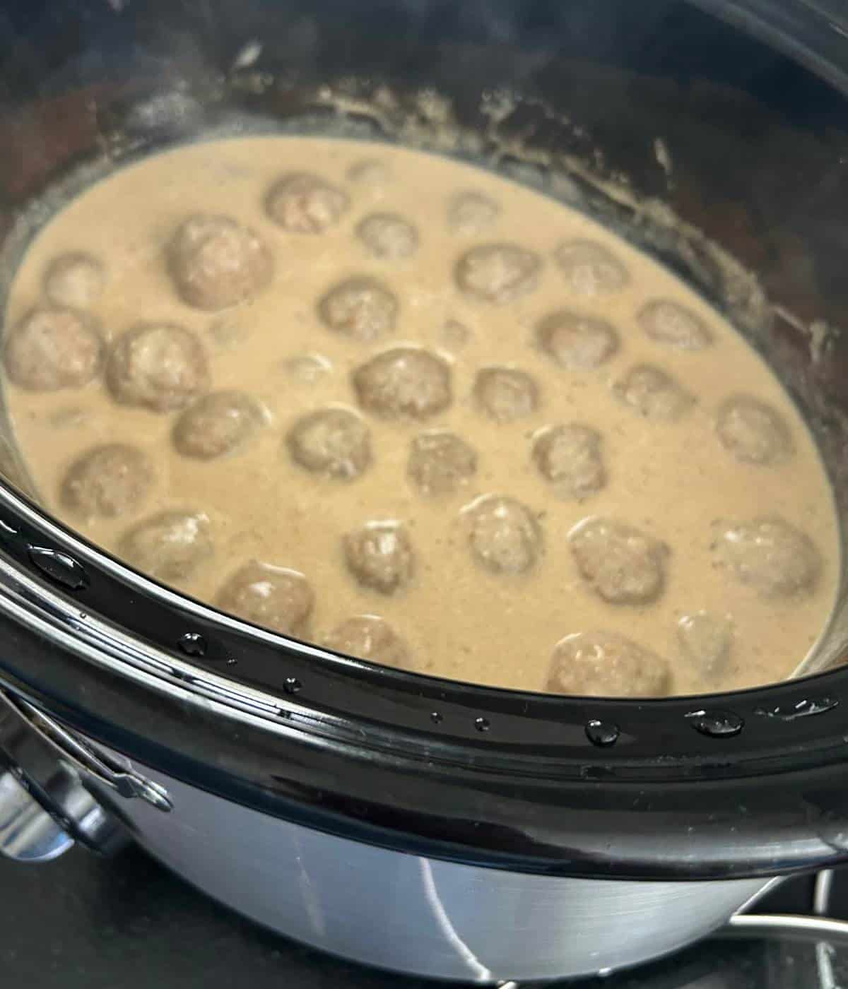 Meatballs in sauce in crockpot.