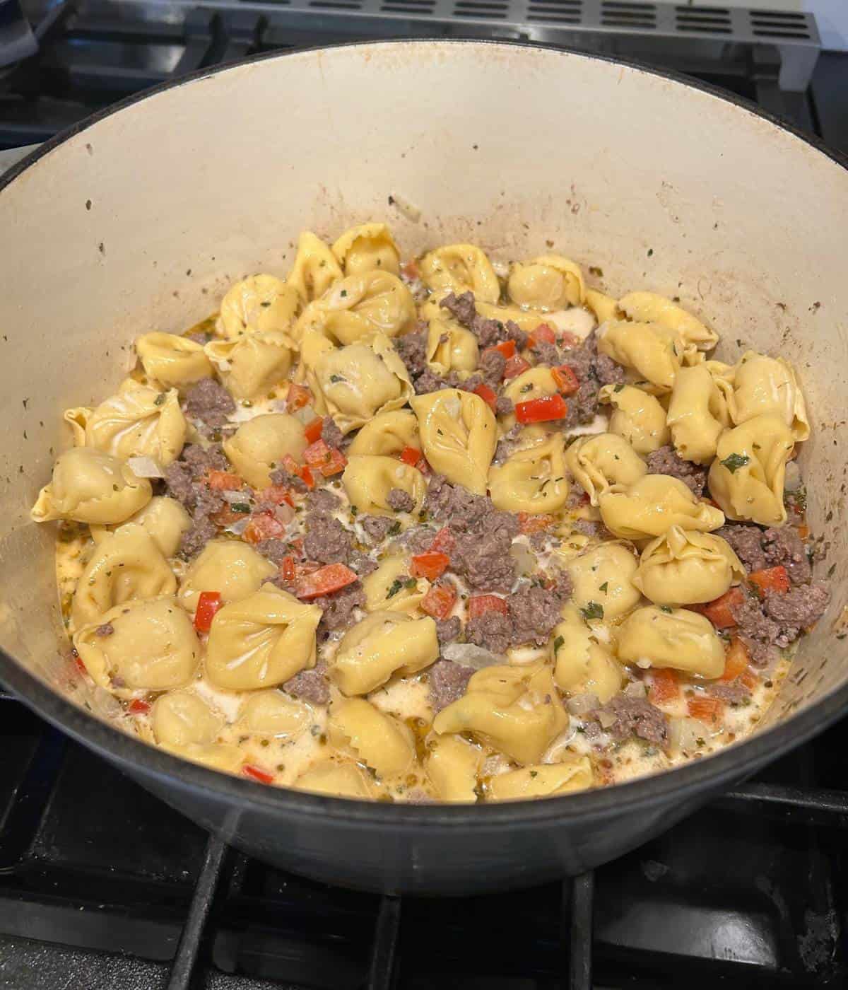 Beef tortellini cooking in dutch oven.