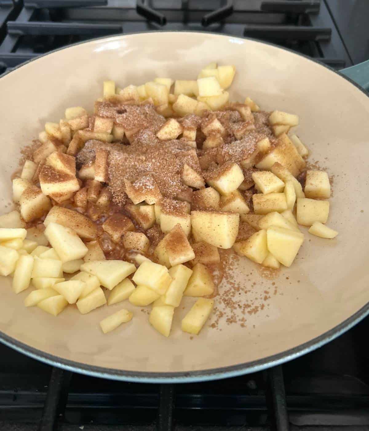 Apples and sugar and spices in skillet.