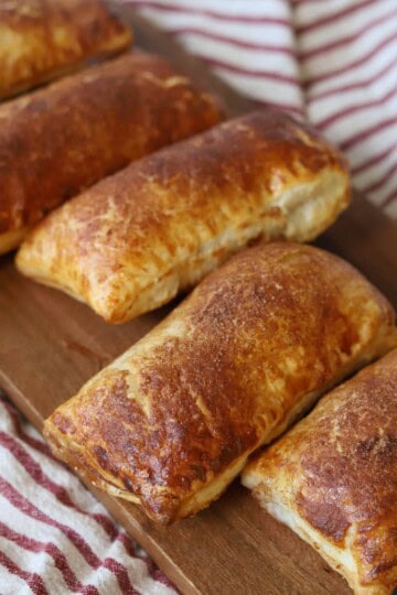Apple hand pies with puff pastry on serving platter.