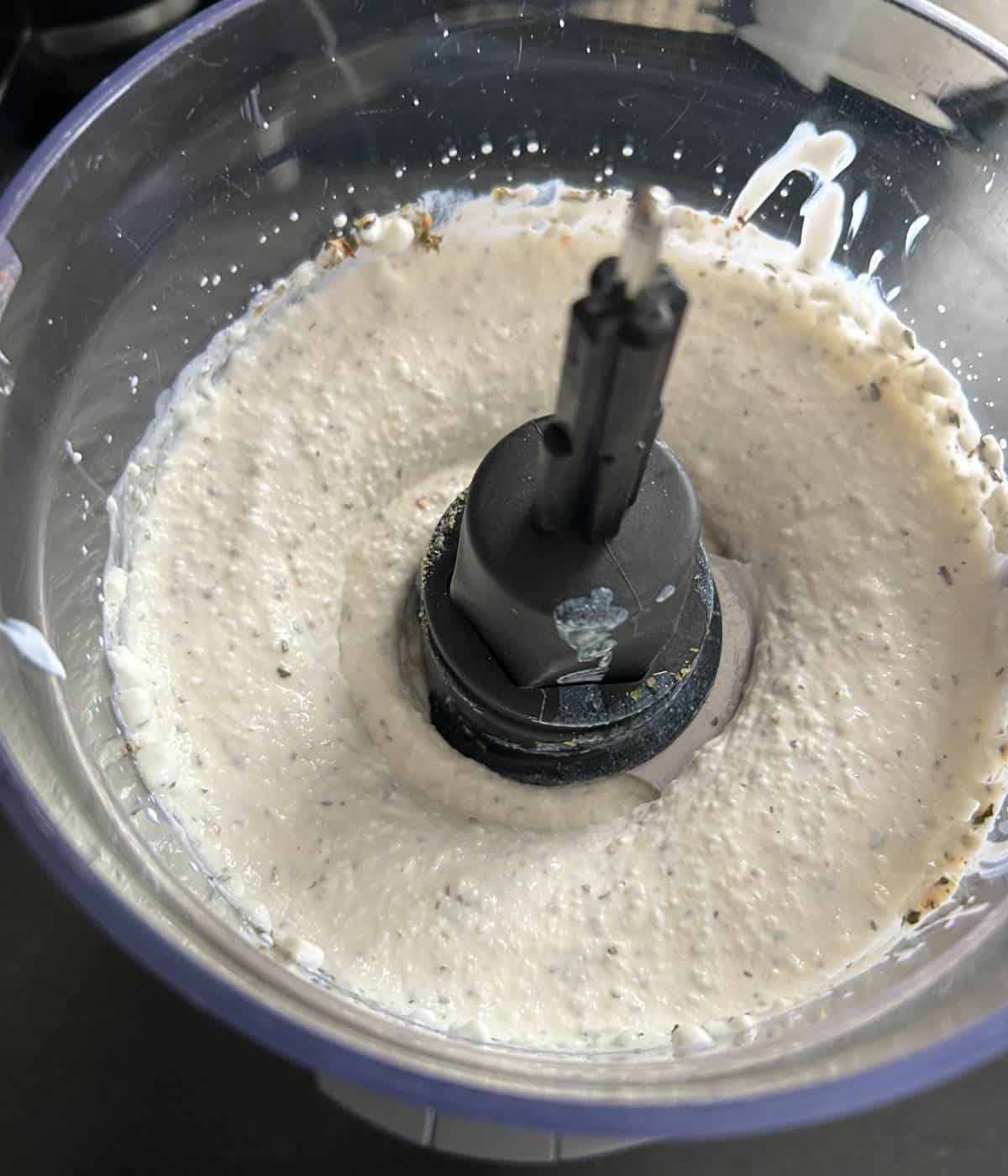 Blending cottage cheese and spices in food processor.