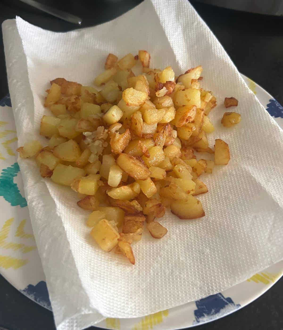 Crispy home fry potatoes on plate.