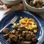 Garlic butter steak bites and potatoes on plate.