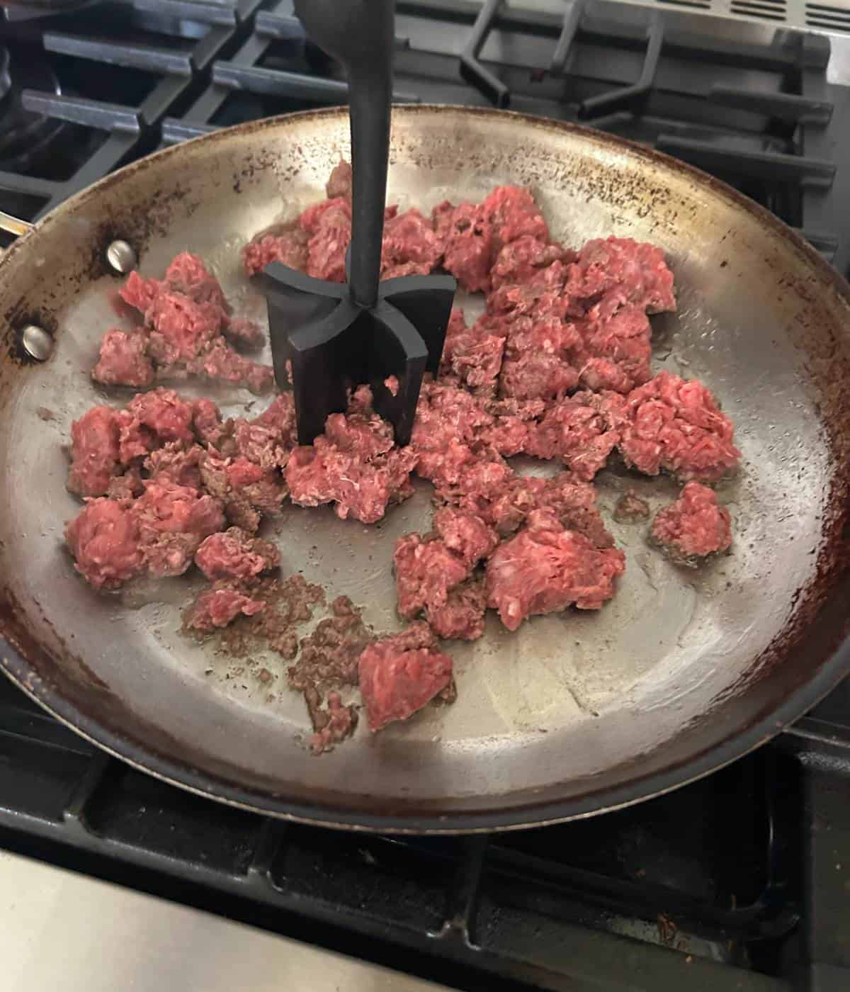 Sautรฉing ground beef in skillet.