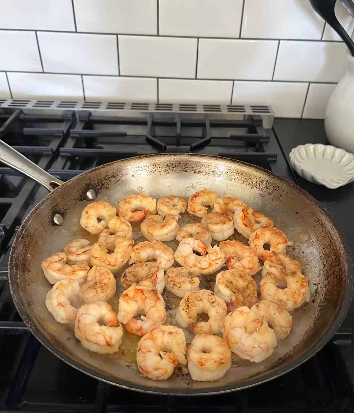 Pan searing shrimp in pan.
