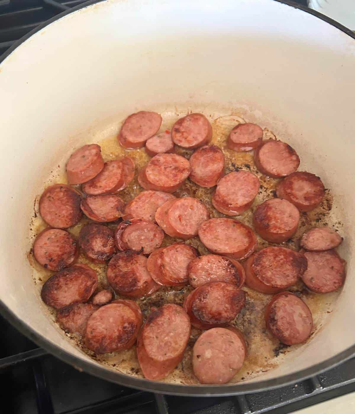 Andouille sausage slices in pot.